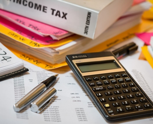 Foto de una calculadora, unos bolis y una carpeta donde guardar todo lo relacionado con el IS